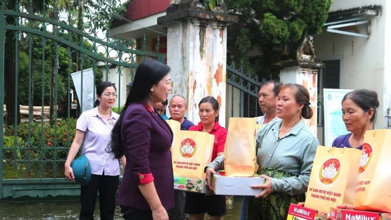 Chủ tịch Ủy ban Mặt trận Tổ quốc Việt Nam thành phố Hà Nội Nguyễn Lan Hương tặng quà và động viên người dân vùng lũ.