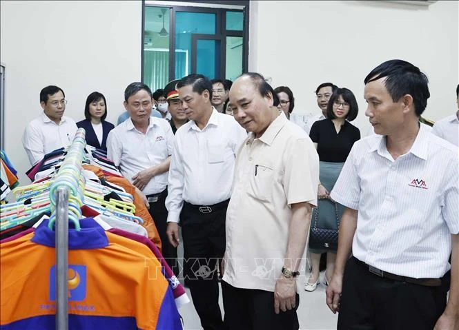 Chủ tịch nước Nguyễn Xuân Phúc thăm nhà máy sản xuất sản phẩm may mặc và mô hình thiết chế công đoàn của Công ty TNHH thương mại Sao Mai, huyện Vĩnh Bảo, thành phố Hải Phòng. (Ảnh: TTXVN)