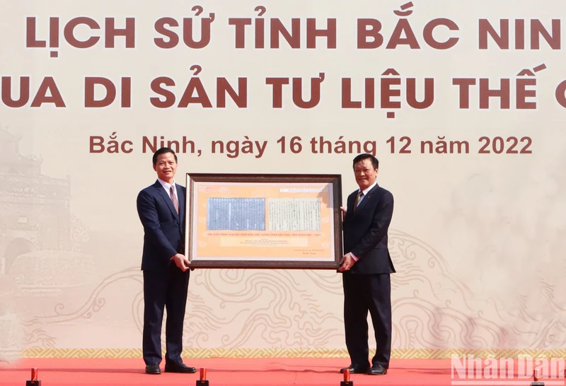 Thứ trưởng Nội vụ Nguyễn Duy Thăng (bên phải) tặng tỉnh Bắc Ninh tư liệu về sự kiện Vua Minh Mạng cho đổi trấn Kinh Bắc thành trấn Bắc Ninh vào năm 1822.