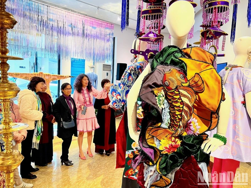 Nhà thiết kế Thủy Nguyễn (váy hồng) giới thiệu các thiết kế với khách tham quan tại triển lãm.