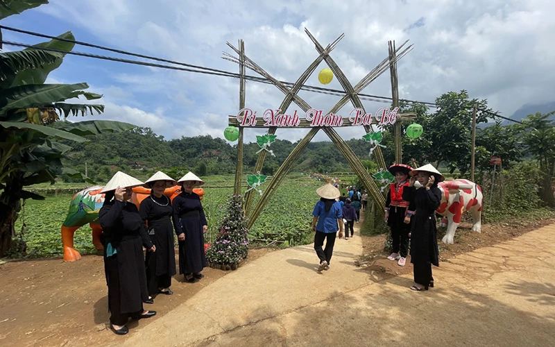 Chương trình du lịch gắn với trải nghiệm bí xanh thơm là sản phẩm du lịch độc đáo. (Trong ảnh: Người dân đón du khách đến thăm vườn bí trong chương trình tổ chức năm 2022). 