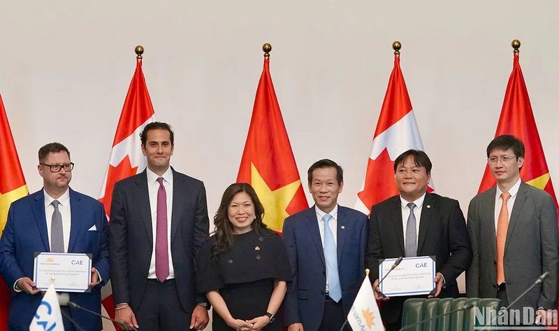 Đại diện Vietnam Airlines và CAE ký gia hạn hợp tác khai thác Buồng lái mô phỏng (SIM) dưới sự chứng kiến của bà Mary Ng, Bộ trưởng phát triển kinh tế, thương mại quốc tế và xúc tiến xuất khẩu Canada.