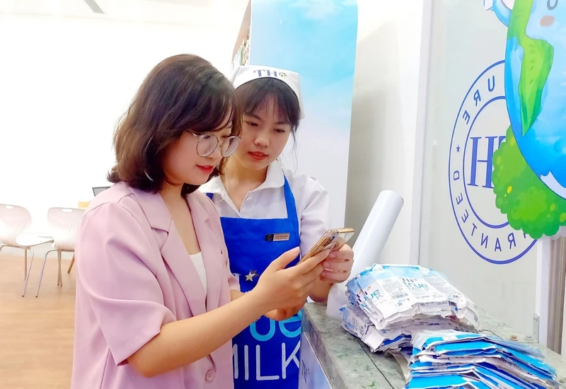 Chị Hiếu Ngân được nhân viên hướng dẫn quét mã quay thưởng khi đến TH true mart tham gia chương trình “Thu gom vỏ hộp, lan tỏa sống xanh 2024”.