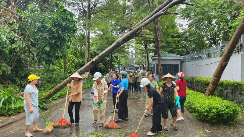 Phụ nữ quận Bắc Từ Liêm quét dọn vệ sinh môi trường sau bão số 3. 