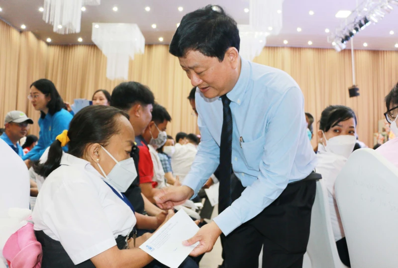 Chủ tịch Ủy ban nhân dân tỉnh Bình Dương Võ Văn Minh trao quà tặng cho công nhân khó khăn, công nhân bị bệnh hiểm nghèo. 