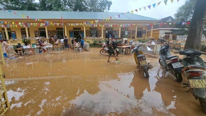 Người dân và các lực lượng ở huyện Quỳ Châu (Nghệ An) hỗ trợ trường học khắc phục hậu quả mưa lũ. (Ảnh: Thành Châu)