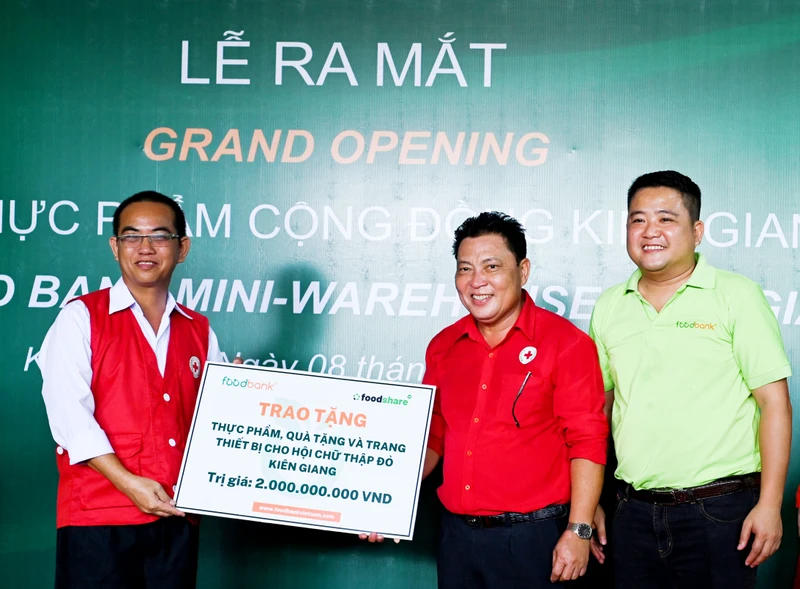 Đại diện Food Bank Việt Nam trao biển tượng trưng tặng thực phẩm, quà tặng và trang thiết bị trị giá 2 tỷ đồng đưa vào vận hành kho thực phẩm cộng đồng Kiên Giang.