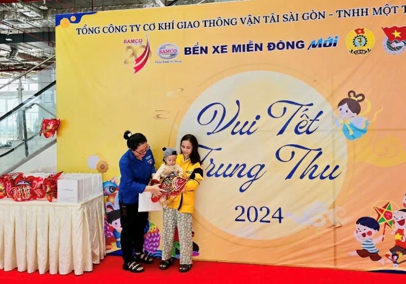 Hành khách có con nhỏ nhận quà Trung thu tại Bến xe Miền Đông mới (Thành phố Thủ Đức), Thành phố Hồ Chí Minh. (Ảnh: QUÝ HIỀN)