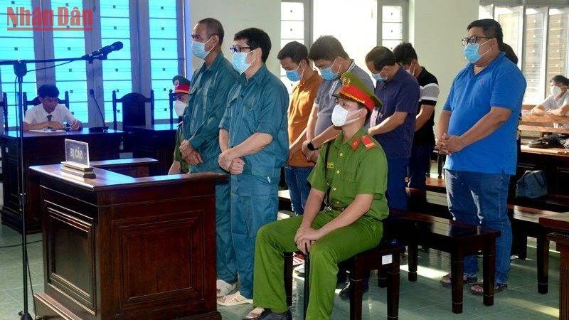 Bị cáo Luyện Xuân Tràng (đứng hàng đầu, đeo kính), chủ mưu vụ án buôn lậu xăng dầu, cùng các bị cáo tại phiên tòa. 