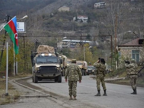 Binh sĩ và xe quân sự của Azerbaijan di chuyển qua thị trấn Lachin, gần khu vực biên giới với Armenia. (Ảnh: AFP/TTXVN)