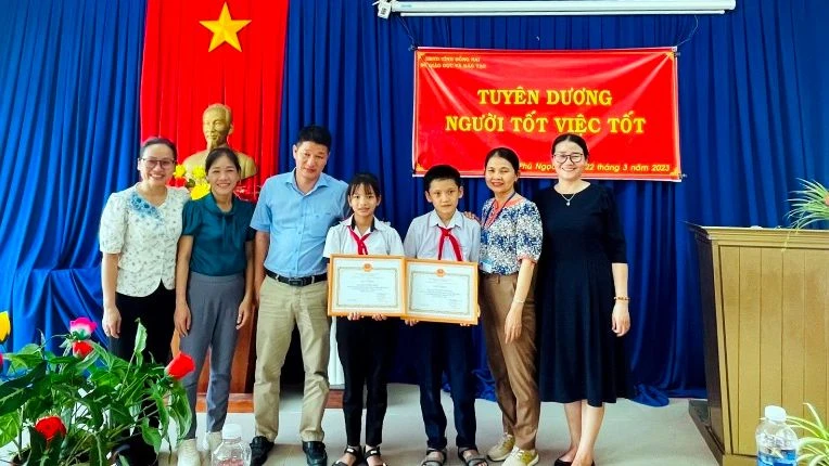 Phó Giám đốc Sở Giáo dục và Đào tạo tỉnh Đồng Nai Đỗ Đăng Bảo Linh tặng Giấy khen cho 2 em học sinh.