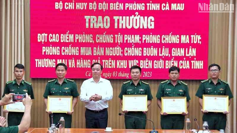 Chủ tịch Ủy ban nhân dân tỉnh Cà Mau Huỳnh Quốc Việt (áo trắng) tặng Bằng khen cho tập thể, cá nhân Biên phòng Cà Mau có thành tích tốt trong phá án về buôn lậu, ma túy.