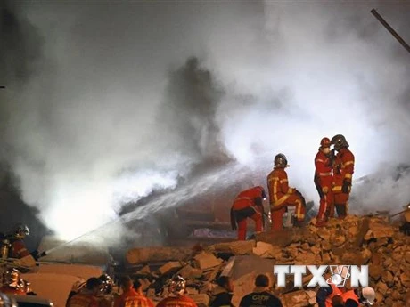 Lực lượng cứu hỏa làm nhiệm vụ tại hiện trường vụ sập nhà ở thành phố Marseille, miền Nam Pháp. (Ảnh: AFP/TTXVN)