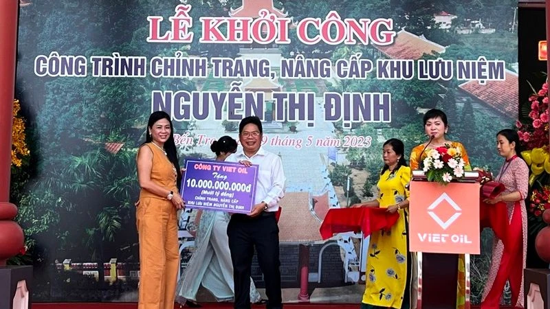 Đại diện nhà tài trợ trao bảng tượng trưng xây dựng công trình chỉnh trang, nâng cấp Khu lưu niệm Nguyễn Thị Định. 