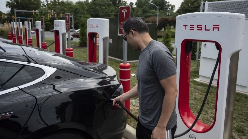 Người dân sạc điện cho ô-tô tại một trạm sạc của Tesla ở Arlington, Virginia, Mỹ. (Ảnh: AFP/TTXVN)