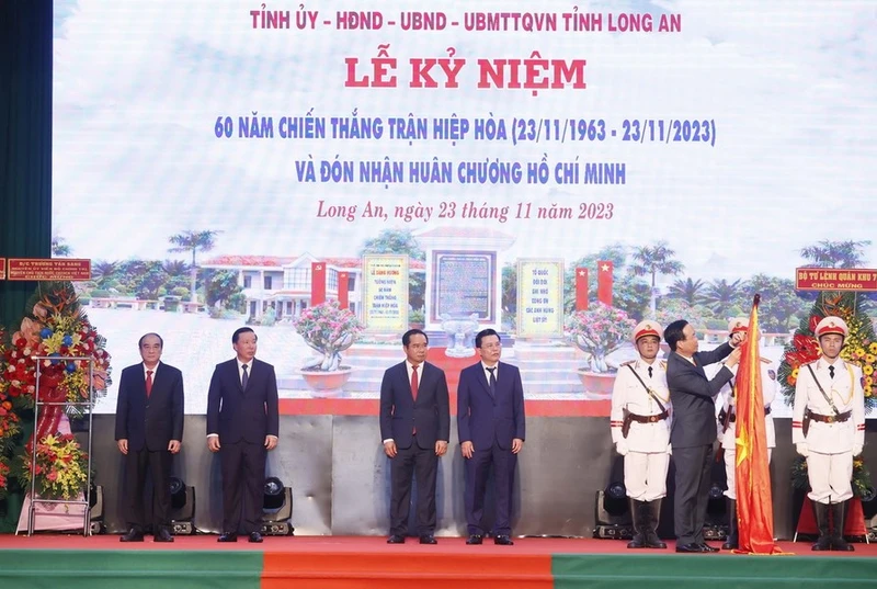 Chủ tịch nước Võ Văn Thưởng gắn Huân chương Hồ Chí Minh lên cờ truyền thống của tỉnh Long An. (Ảnh: Thống Nhất/TTXVN)