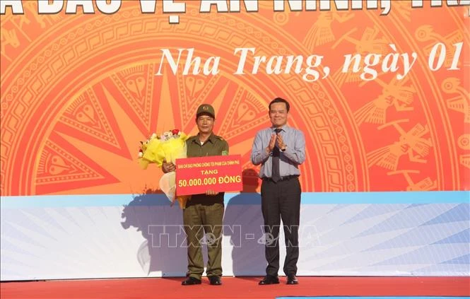 Phó Thủ tướng Chính phủ Trần Lưu Quang, Ủy viên Trung ương Đảng, Trưởng Ban Chỉ đạo 138 Chính phủ tặng quà cho đại diện Lực lượng tham gia bảo vệ an ninh trật tự ở cơ sở trên địa bàn thành phố Nha Trang. 