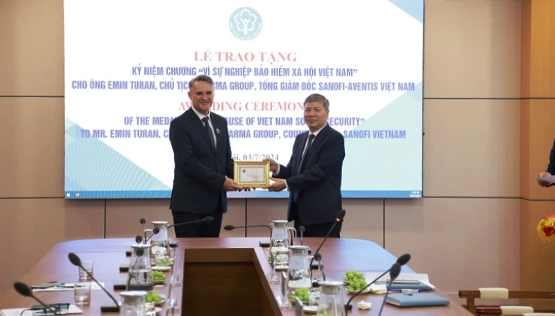 Phó Tổng Giám đốc Bảo hiểm xã hội Việt Nam Nguyễn Đức Hòa trao tặng Kỷ niệm chương “Vì sự nghiệp Bảo hiểm xã hội Việt Nam” cho ông Emin Turan. (Ảnh: VSS)