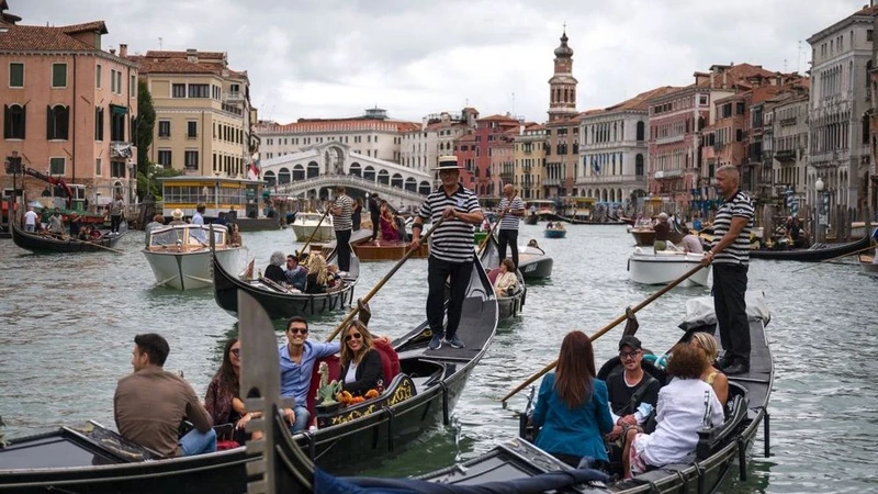 Du khách đi thuyền gondola tại Venice, Italy. (Ảnh: AFP/TTXVN)