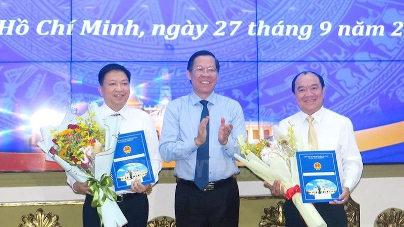 Đồng chí Phan Văn Mãi, Chủ tịch Ủy ban nhân dân Thành phố Hồ Chí Minh trao quyết định cho đồng chí Võ Thành Khả và đồng chí Lê Văn Thành (bìa phải).