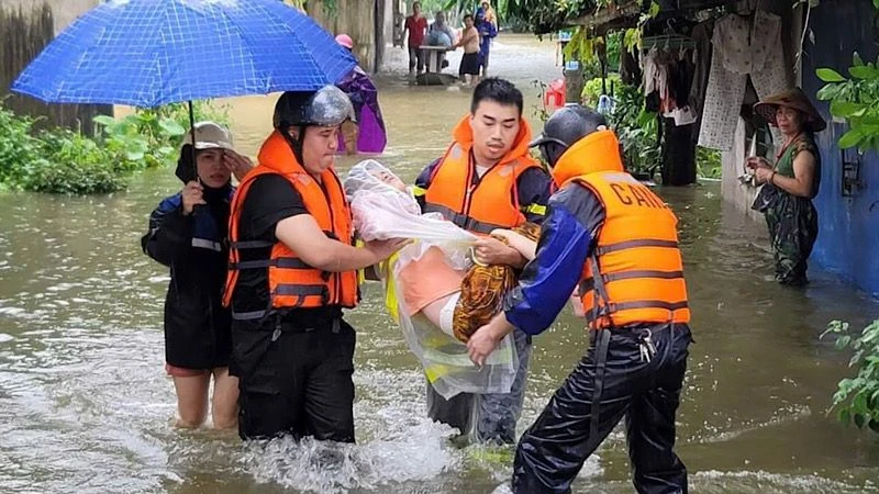 Lực lượng xung kích hỗ trợ di dời người dân khỏi vùng ngập lụt ở Nam Định.