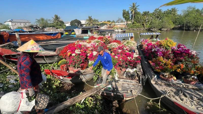 Người dân mang hoa lên ghe để vận chuyển bằng đường thủy đến chợ Tết.