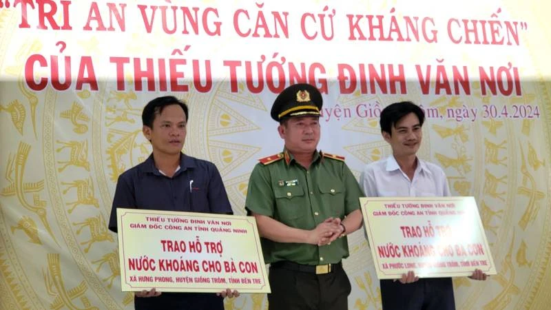 Thiếu tướng Đinh Văn Nơi trao bảng tượng trưng hỗ trợ nước khoáng cho người dân vùng hạn mặn tại tỉnh Bến Tre.
