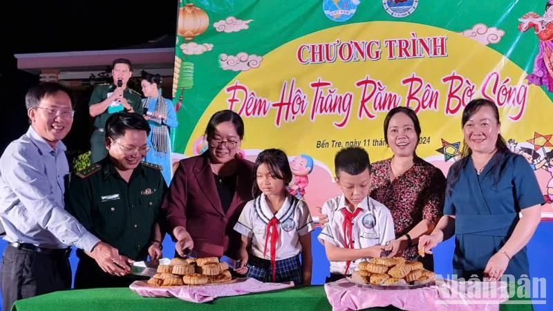 Đại biểu tham dự Chương trình cùng các cháu thiếu nhi thực hiện nghi thức Phá cỗ Trung thu. (Ảnh: MINH NGỌC)