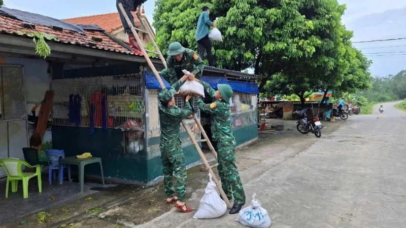 Cán bộ, chiến sĩ Đồn Biên phòng Cửa khẩu cảng Vạn Gia giúp nhân dân chằng chống, gia cố nhà cửa trước khi bão đổ bộ.