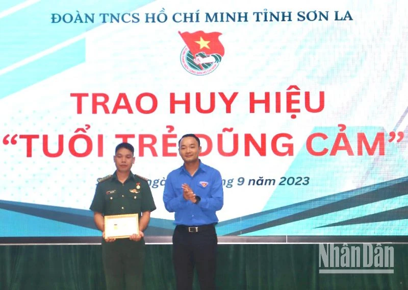 Đồng chí Nguyễn Duy Dũng, Phó Bí thư Thường trực Tỉnh đoàn Sơn La trao Huy hiệu “Tuổi trẻ dũng cảm” cho đại úy Quàng Văn Tám.