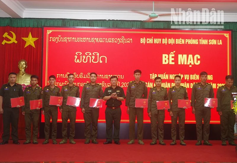 Đại tá Bàn Văn Chanh, Phó chỉ huy trưởng Bộ đội Biên phòng tỉnh Sơn La trao giấy chứng nhận cho các đồng chí học viên Lào. (Ảnh: Vì Hiện)