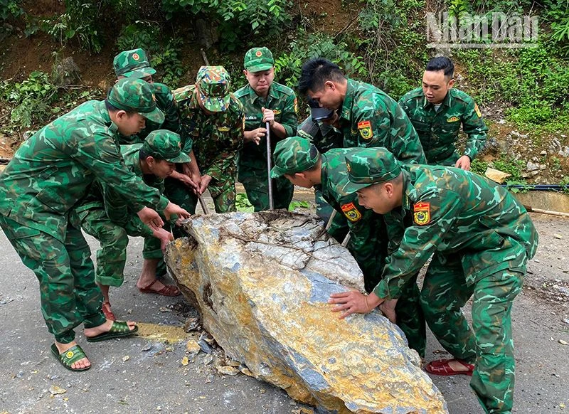 Cán bộ, chiến sĩ Đồn Biên phòng Chiềng Tương, Bộ đội Biên phòng tỉnh Sơn La khắc phục tuyến đường bị đá sạt lở chắn ngang.