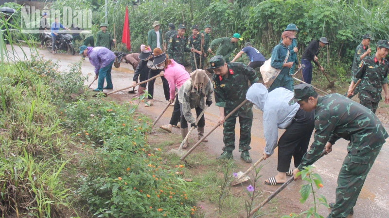 Các lực lượng và người dân các bản tham gia dọn dẹp, phát quang cỏ hai bên đường. 