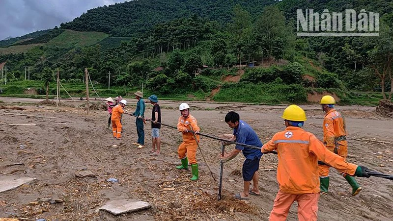 Công nhân Điện lực khu vực Mai Sơn-Yên Châu cùng nhân dân dựng cột tạm, kéo dây cấp điện trở lại cho người dân bản Nhụng Trên.