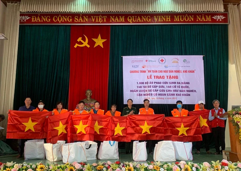 Đại diện Hội Chữ thập đỏ Hà Tĩnh trao áo phao đa năng cho ngư dân huyện Lộc Hà (Hà Tĩnh).