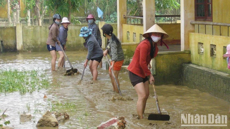 Giáo viên các trường học ở huyện Lệ Thủy dọn bùn, vệ sinh trường lớp để học sinh đi học trở lại.