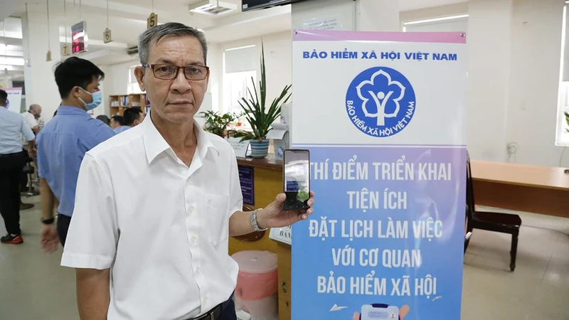 Ông Vũ Quốc Thúc (59 tuổi, quận Bình Thạnh, Thành phố Hồ Chí Minh) trải nghiệm tiện ích dịch vụ mới của ngành Bảo hiểm xã hội Việt Nam.