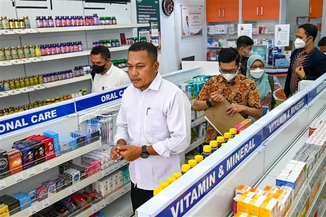 Nhà chức trách kiểm tra thuốc siro ho tại một hiệu thuốc ở Banda Aceh (Indonesia), ngày 24/10/2022. (Ảnh: AFP/TTXVN)