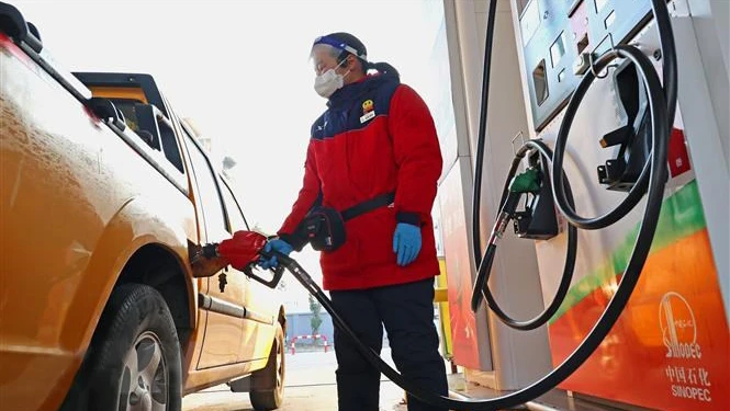 Bơm xăng cho các phương tiện tại một cây xăng ở tỉnh Giang Tô, Trung Quốc. (Ảnh: AFP/TTXVN)