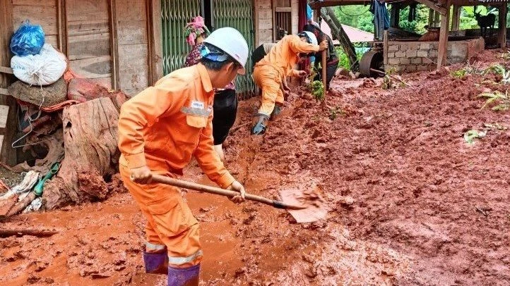 Công nhân Điện lực Tân Uyên PC Lai Châu hỗ trợ bà con nhân dân khắc phục sau mưa lũ.