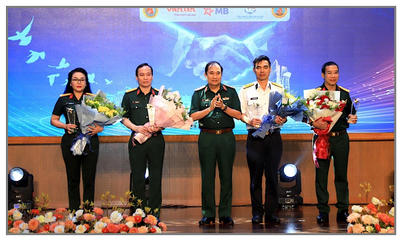 Thượng tướng Phùng Sĩ Tấn trao hoa và biểu chương tặng đại diện các đơn vị tài trợ triển lãm.