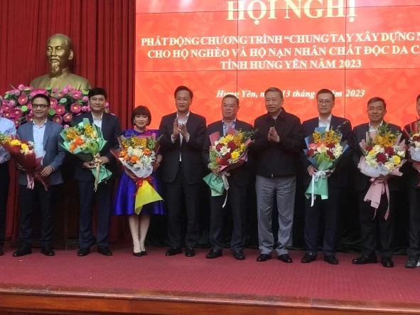 Bộ trưởng Công an Tô Lâm tặng hoa cho đại diện các tổ chức kinh tế, doanh nghiệp đã tài trợ xây nhà ở cho hộ nghèo, hộ nạn nhân chất độc da cam ở tỉnh Hưng Yên.