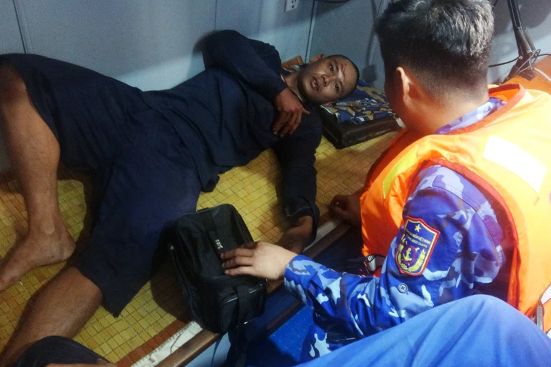 Lực lượng thuộc Bộ Tư lệnh Vùng Cảnh sát biển 4 sơ cấp cứu ban đầu cho ngư dân Võ Thanh Nam. (Ảnh: Bộ Tư lệnh Vùng Cảnh sát biển 4 cung cấp).