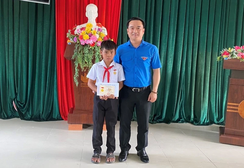 Anh Đỗ Duy Nam trao huy hiệu "Tuổi trẻ dũng cảm" cho em Kpă Nguyên. 
