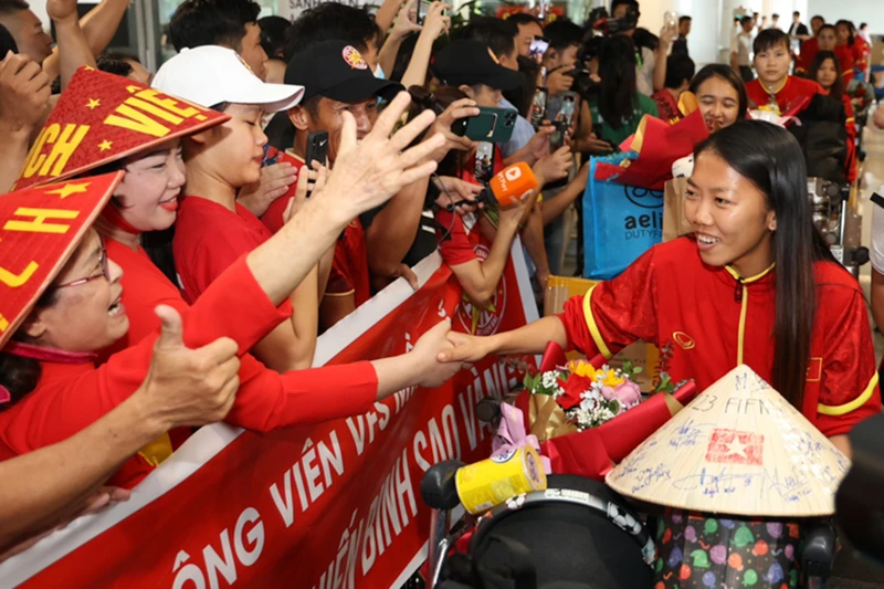 Đội trưởng Huỳnh Như được người hâm mộ chào đón tại sân bay Nội Bài. (Ảnh: VFF)