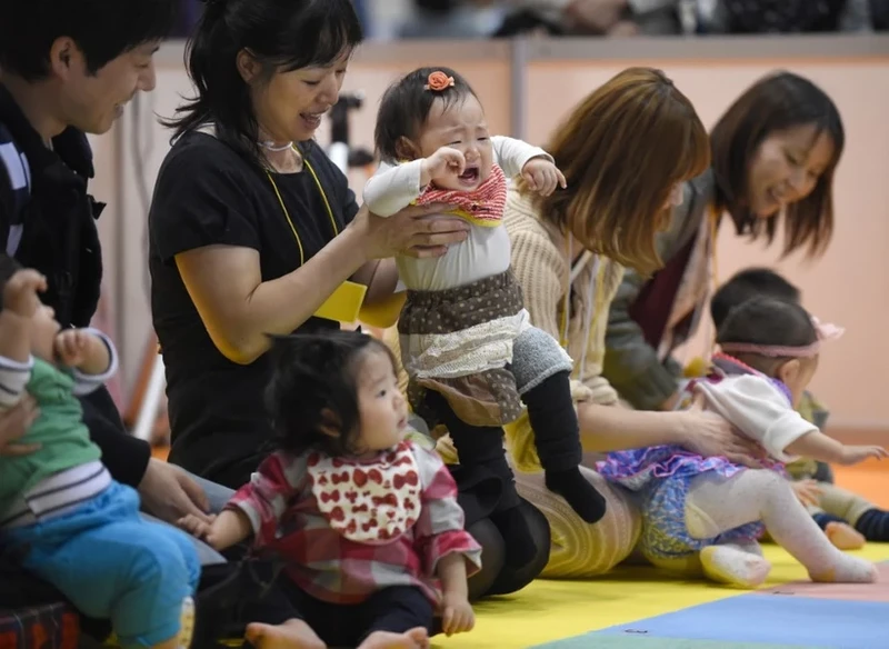 Cha mẹ cùng các em bé tham gia một cuộc thi ở Tokyo (Nhật Bản). (Ảnh: TTXVN)
