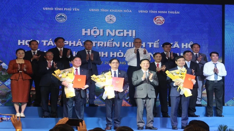 Phó Chủ tịch Quốc hội Nguyễn Khắc Định (hàng trước, thứ hai từ phải sang) tặng hoa lãnh đạo các tỉnh Khánh Hòa, Phú Yên và Ninh Thuận tại lễ ký kết. (Ảnh: PHONG NGUYÊN) 