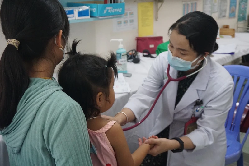 Bác sĩ Bệnh viện Nhi đồng 2 TP Hồ Chí Minh khám cho một trường hợp trẻ có dấu hiệu bệnh tay chân miệng. Ảnh: Lê Cầm
