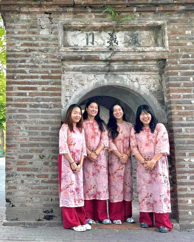 My và Vy (ở giữa), trong trang phục Việt Nam truyền thống, bên tháp Hòa Phong. 
