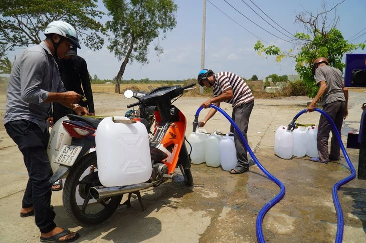 Người dân hứng nước tại một điểm cho nước ở huyện Gò Công Đông, tỉnh Tiền Giang. Ảnh: MẬU TRƯỜNG